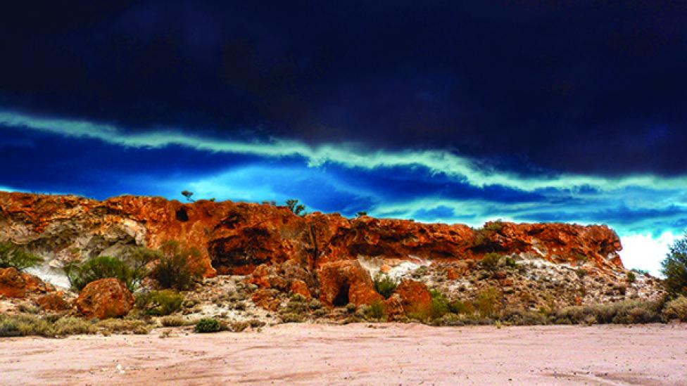 A visibly cloudy storm front dramatically approaching the shoreline